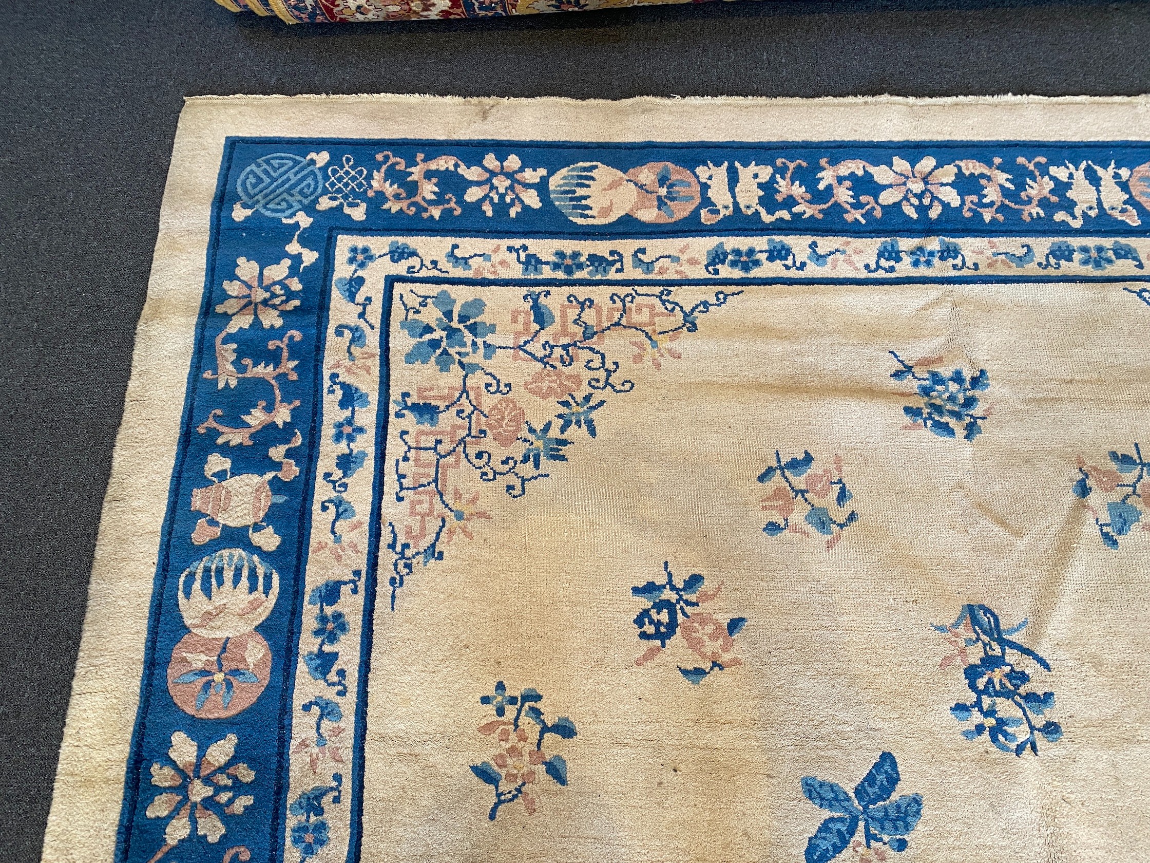 A Chinese ivory ground carpet with scattered floral field 368 x 284 cms